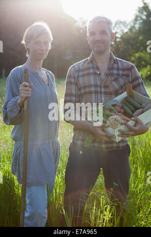 Porträt von reifes Paar mit Kiste von erntefrischem Gemüse im Gemeinschaftsgarten Stockfoto