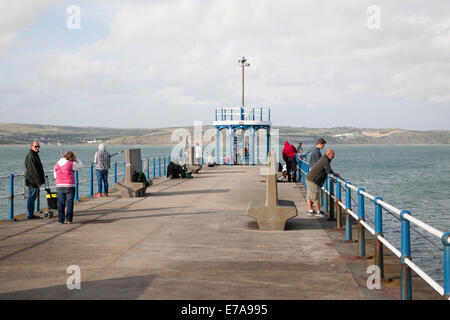 Menschen, die Angeln vom Wellenbrecher Hafenpier bei Weymouth, Dorset, England Stockfoto