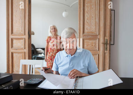 Senior woman finanziellen Dokumente mit Frau im Hintergrund zu Hause überprüfen Stockfoto