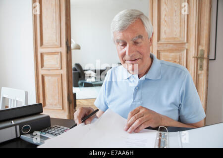 Senior woman Überprüfung Finanzdokumente am Tisch Stockfoto