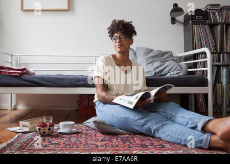 Junge Frau im Schlafzimmer Magazin lesen Stockfoto