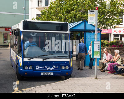 Menschen warten auf den Bus an der Bushaltestelle im Stadtzentrum Teignmouth, Devon, UK. Stockfoto