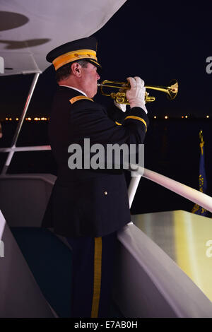 Freeport, New York, USA. 10. September 2014. Ein Hornist spielt Hähne in der Nacht an Bord des Bootes Miss Freeport V, die nach einem Dockside-Gedenkveranstaltung zu Ehren der Opfer der Terroranschläge des 11. September 2001 aus dem Woodcleft-Kanal von Freeport Seemeilen gesegelt. American Legion, Patriot Guard Riders und Kapitän Frank Rizzo veranstaltet die Zeremonien am Vorabend des 13. Jahrestag von 9/11 Angriffe. © Ann Parry/ZUMA Draht/Alamy Live-Nachrichten Stockfoto