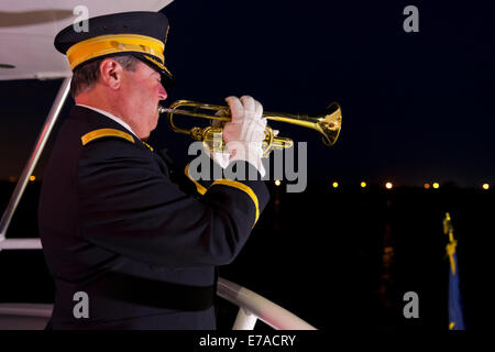 Freeport, New York, USA. 10. September 2014. Ein Hornist spielt Hähne in der Nacht an Bord des Bootes Miss Freeport V, die nach einem Dockside-Gedenkveranstaltung zu Ehren der Opfer der Terroranschläge des 11. September 2001 aus dem Woodcleft-Kanal von Freeport Seemeilen gesegelt. American Legion, Patriot Guard Riders und Kapitän Frank Rizzo veranstaltet die Zeremonien am Vorabend des 13. Jahrestag von 9/11 Angriffe. Bildnachweis: Ann E Parry/Alamy Live-Nachrichten Stockfoto