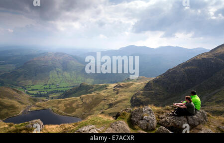 Zwei Menschen sitzen auf dem Gipfel des Pavey Arche Teil des Langdale Pikes in den Lake District Cumbria North West England UK Stockfoto