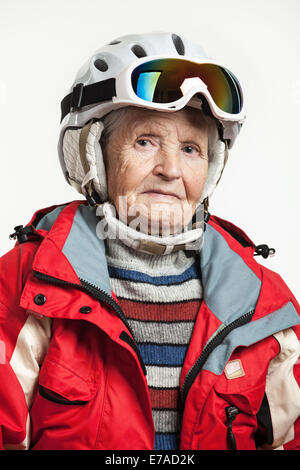 Porträt von senior Frau in Ski-Jacke und Helm über weiß Stockfoto