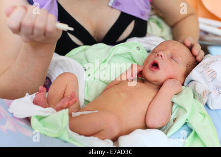 Mutter füttert Neugeborenes Babymilch mit Spritze zu Hause Stockfoto