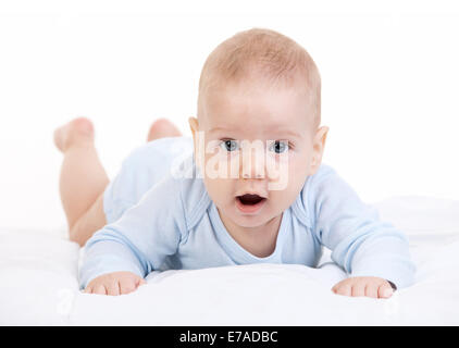 Kleiner Junge auf Bauch liegend und Blick in die Kamera auf weißem Hintergrund Stockfoto