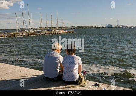 Junges Paar genießen den Blick über den Strelasund nach Stralsund von Altefähr auf der Insel Rügen, Mecklenburg-Vorpommern, Deutschland. Stockfoto
