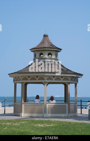 New York, Rochester, Ontario Strand. Zwei Frauen Blick auf Lake Ontario und Segelboote aus Park Pavillon an ruhigen Sommertag. Stockfoto