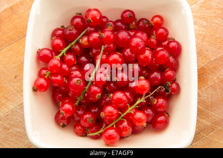 frische Johannisbeeren in Schüssel auf Holztisch Stockfoto