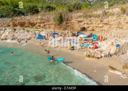 Touristen an einem Strand in der Nähe von Erdpech Campingplatz in Ivan Dolac Dorf, Insel Hvar, Kroatien Stockfoto