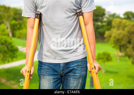 Nahaufnahme des Beines auf Bandage mit Krücken Stockfoto