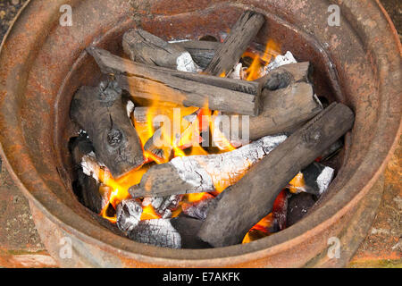 brennende Holzkohle in Metallrand Stockfoto