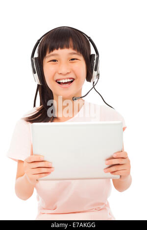 glückliche kleine Asiatin hält ein Tablet mit Kopfhörer Stockfoto
