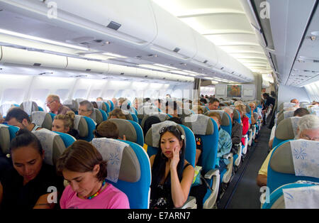 Passagiere an Bord eines Airbus 340 sitzen in der Economy-Kabine. Stockfoto