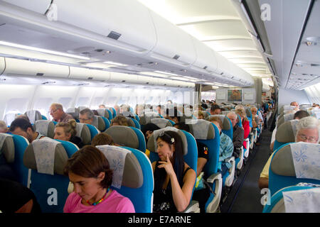 Passagiere an Bord eines Airbus 340 sitzen in der Economy-Kabine. Stockfoto