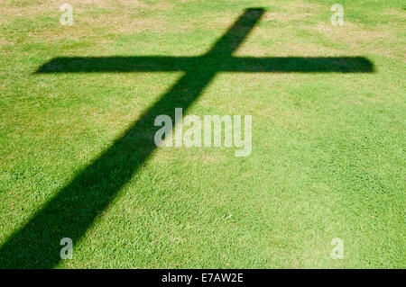 Schatten eines Kreuzes auf Rasen auf dem deutschen Soldatenfriedhof Cannock Staffordshire UK Stockfoto