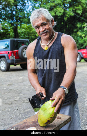 Kokos-Anbieter David Kaaumoang verkauft frische Kokosnüsse auf Kauai an Touristen in den North Shore Stockfoto