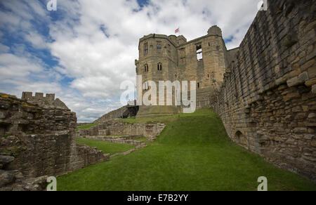 Ansicht der Ruinen des historischen Schlosses mit grünen Wiesen und blauem Himmel in Warkworth Northumberland, England Stockfoto