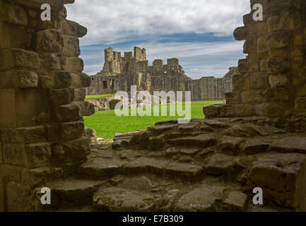 Blick durch die Lücke in der Steinmauer, umfangreiche Ruinen des historischen Schlosses in Warkworth Northumberland, England Stockfoto