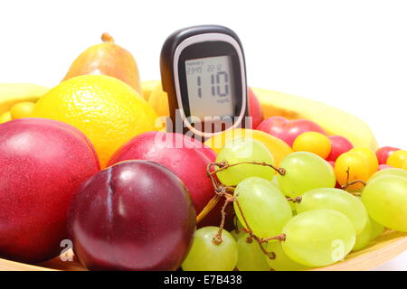 Frische reife Früchte und Glukose Meter liegen auf Holzplatte, Konzept für gesunde Ernährung und Diabetes. Isoliert auf weißem Hintergrund Stockfoto