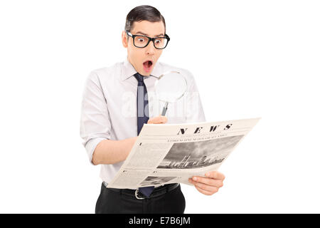 Schockiert Mann liest die Nachrichten durch eine Lupe isoliert auf weißem Hintergrund Stockfoto