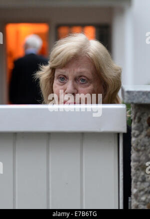 München, Deutschland. 11. September, 2014. Die Frau des verstorbenen deutschen Schauspieler und TV-Legende steht Joachim "Blacky" Fuchsberger, Gundula Fuchsberger im Gateway ihres Hauses wie der Körper des Mannes in Grünwald bei München, 11. September 2014 weggetragen wird. Fuchsberger starb im Alter von 87 in seinem Haus am 11. September 2014. Foto: ANDREAS GEBERT/Dpa/Alamy Live-Nachrichten Stockfoto