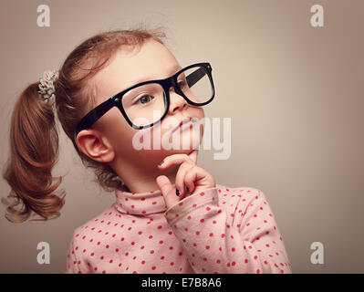 Denken süßes Kind Mädchen in schwarzen Brille suchen. Instagram-Effekt-Porträt Stockfoto