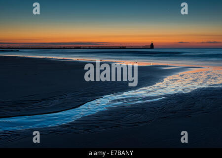 Vom frühen Morgen an Blyth. Linie durch Reflexion am Wasser führt in Richtung Meer, Leuchtturm und dem Pier. Sie können auch vor Ort Stockfoto