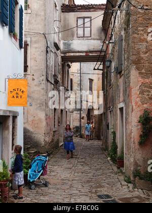 Ein Durchgang zwischen den Häusern in Groznjan (Grisignana), Kroatien. Ein Geschäft kann gesehen werden. Stockfoto