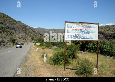 Stepanakert, Armenien. 26. Juni 2014. Ein Zeichen in Armenisch, Russisch und Englisch informiert höflich einen Reisepass und ein Visum Kontrollen bei der Eingabe der Republik Bergkarabach an der Straße von Goris nach Stepanakert, Armenien, 26. Juni 2014. Die Republik Bergkarabach ist aber international ein de facto unabhängiger Staat zwischen Armenien und Aserbaidschan umstritten unerkannt. Die Binnenstaat Region im Südkaukasus ist von Armeniern bewohnt. Foto: Jens Kalaene - kein Draht-SERVICE-/ Dpa/Alamy Live News Stockfoto