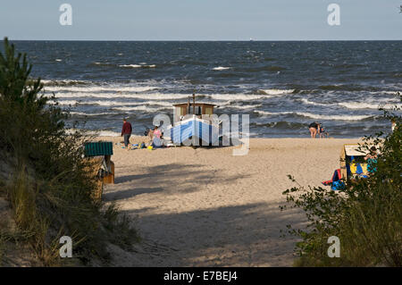 Angeln Boot & Holiday Maker am Strand von Heringsdorf auf der Insel Usedom, Mecklenburg Western Pomerania, Deutschland Stockfoto