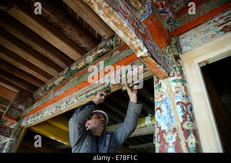 (140912)--XIAHE, 12. September 2014 (Xinhua)--ein Arbeiter Reparaturen eine hölzerne Struktur im Inneren der Residenz die erste Jamyang Shepa, Gründer des Klosters Labrang in Xiahe County der Gannan tibetischen autonomen Präfektur im Nordwesten Chinas Provinz Gansu, 2. September 2014. Labrang Kloster, einem großen tibetischen Buddhismus-Kloster in China, erlebt die größte Renovierung Programm seit seiner Gründung im Jahre 1709. Die Renovierung, die im April 2013 gestartet, soll ersetzen Stein- und hölzernen Strukturen innerhalb des Klosters, die von den Jahren abgenutzt. Das Labrang Kloster re Stockfoto