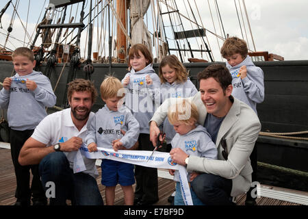 Kinder aus dem Andrew Simpson Segeln Foundation Charity posieren mit Matt Baker und Iain Percy auf der Southampton Boat show 2014. Stockfoto