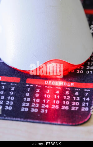 Eine Computer-Maus auf einem Kalender Mauspad beleuchtet den Monat Dezember, vor allem Weihnachten Stockfoto