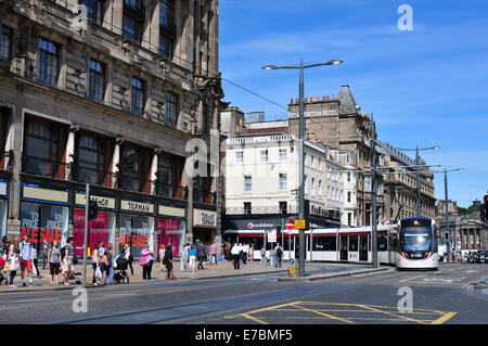 Eine Straßenbahn fährt hinunter Princes Street, Edinburgh, Schottland, an einem hellen Sommertag. Stockfoto