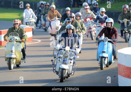 Quadrophenia-Star Phil Daniels eröffnete das Goodwood Revival 2014, indem er eine Gruppe von „Mods“ auf der Rennstrecke leitete und einen Motorroller in Retro-Kleidung fuhr Stockfoto