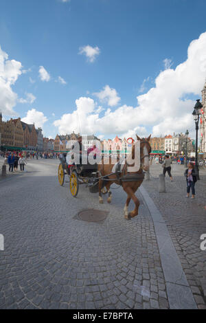 Eine Pferdekutsche Kutsche mit Touristen in der Grote Markt im Herzen von Brügge, West-Flandern, Belgien Stockfoto