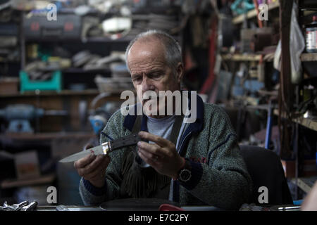 Buenos Aires, Argentinien. 12. Sep, 2014. Die Handwerker, Martin Onetto, setzt das Mahagonie Holz Handle für ein Messer in seiner Werkstatt, in der Stadt Villa Adelina, 20km von Buenos Aires, der Hauptstadt von Argentinien, auf 12. September 2014. Onetto ist ein Handwerker von Besteck seit 20 Jahren, der Prozess ist komplett handgefertigt außer Metall Temperament. Das Cuttermesser ist sehr beliebt in Argentinien, eines der Elemente, die durch die "Gauchos" verwendet. © Martin Zabala/Xinhua/Alamy Live-Nachrichten Stockfoto