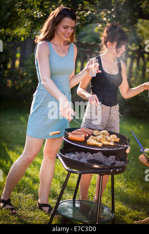Zwei hübsche Mädchen, die Zubereitung von Essen auf grill Stockfoto