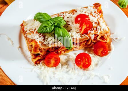 Italienische Lasagne mit Tomaten und Gemüse und Käse auf Holztisch Stockfoto