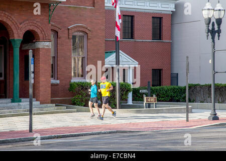 Passen Sie junges Paar Joggen vorbei an der alten historischen Nassau County Courthouse in Fernandina Beach, Florida, USA. Stockfoto