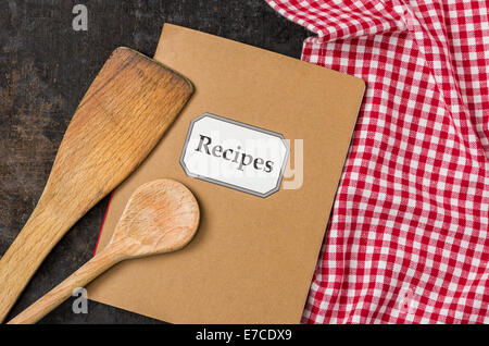 Rezeptbuch mit Kochlöffel auf einem rot karierten Tischdecke Stockfoto