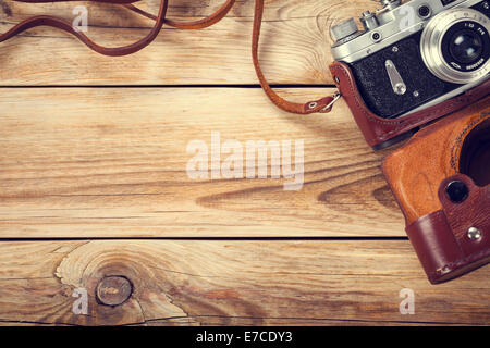 Alte Retro-Kamera auf Holztisch Hintergrund. Kopieren Sie Raum. Ansicht von oben Stockfoto