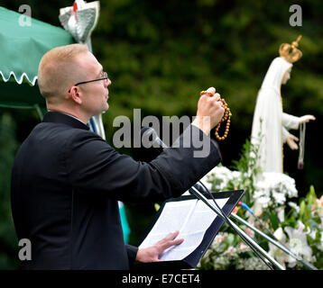 Fallowfield, Manchester, UK 13. September 2014 Fr Simon Stamp, ein junger Priester aus Accrington, hält Rosenkranz in seiner kurzen Predigt. Die Legion Mariens hält seinen 41. Annual Rosenkranz Kreuzzug in Platt Fields Park. Rund sechzig Katholiken besuchen, rezitieren den Rosenkranz, singen Lieder und mit einer kleinen Prozession. Rosenkranz Kreuzzug Manchester, UK Stockfoto