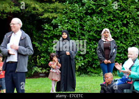 Fallowfield, Manchester, UK 13. September 2014 Frau in außereuropäischen Kleid am Rande der Gemeinde, steht während ein Priester seiner Predigt gibt. Die Legion Mariens hält seinen 41. Annual Rosenkranz Kreuzzug in Platt Fields Park. Rund sechzig Katholiken besuchen, rezitieren den Rosenkranz, singen Lieder und mit einer kleinen Prozession. Rosenkranz Kreuzzug Manchester, UK Stockfoto