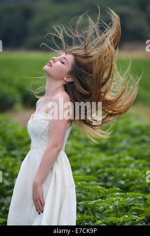 Eine junge Frau in einem grünen Feld von Auberginen, Kibbutz Ha'solelim, Israel Stockfoto