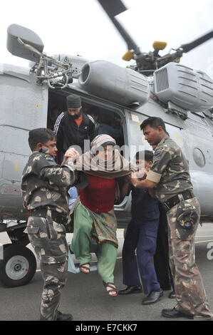 Soldat der indischen Armee helfen, eine ältere Frau aus einer IAF Hubschrauber während der Rettungs- und Hilfskräfte Vorgänge nach Überschwemmungen in Srinagar am 12. September 2014 steigen. Überschwemmungen und Erdrutsche von Tagen von heftigen Monsunregen haben jetzt mehr als 450 lebt in Pakistan und Indien, mit Krankenhäusern, die kämpfen, um mit der Katastrophe fertig zu werden behauptet © Stringer/Pacific Press/Alamy Live News Stockfoto