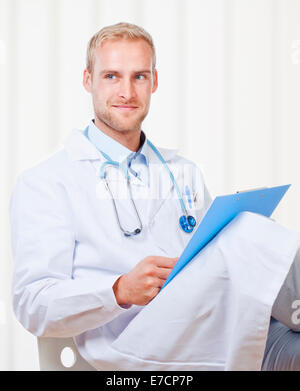 Porträt des jungen Arzt mit Stethoskop und Dateien Stockfoto
